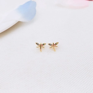 Macro detail of golden dragonfly stud earrings with colorful zircon wing inlay