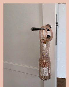 Close-up of champagne mesh wine bag with circular resin handles and sparkling finish