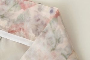 Macro détaillée du tissu imprimé floral et double couture de précision sur le col