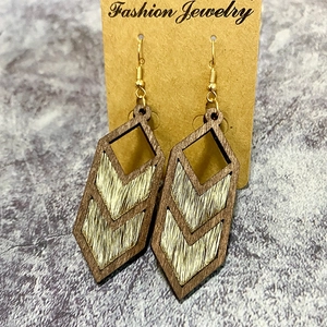 Detail of V-shaped wood and cow print leather earrings on a Fashion Jewelry card