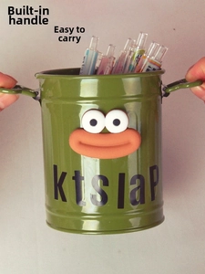 Close-up of green metal pen holder with cute frog design and portable metal handles