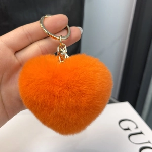Detail of soft orange heart plush keychain with premium golden metal ring and hook