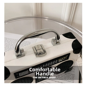Detail of vintage radio-style bag with silver metal handle and buckle on white knit fabric