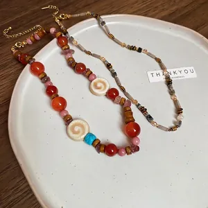 Bohemian multilayer necklace with agate, ceramic, wood beads and shell accents in a tray