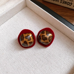 Close-up of retro leopard print stud earrings with red velvet borders in a jewelry box
