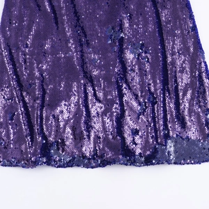 Dettaglio ravvicinato di paillettes viola scintillanti su un elegante abito da sera