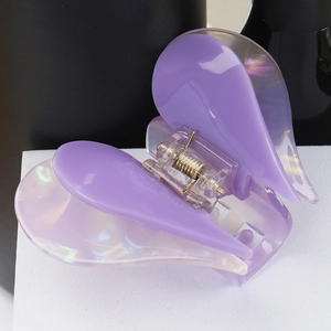 Close-up of a purple acetate double heart hair claw clip with glossy finish and metal spring