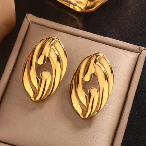 Detail of 18K gold plated earring with hollow oval design and spiral texture on surface