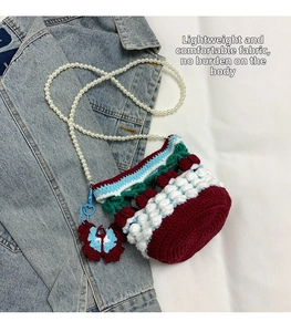 Macro detail of hand-knitted bucket bag featuring 3D texture and decorative butterfly charm
