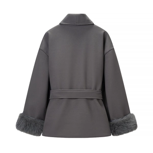 Detail view of the elegant grey wool coat featuring luxury faux fur cuffs and a belted waist