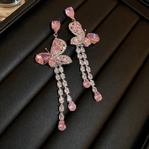 Vue détaillée de boucles d'oreilles papillon roses avec longs glands et pierres zircon