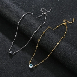 Gold and silver stainless steel evil eye anklets with beads on black background