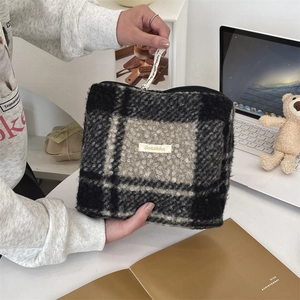 Macro-opname van geruite fleece make-uptas met ritssluiting en zachte pluche textuur