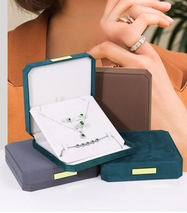Deep green velvet jewelry set box featuring metal accents for pearls and rings