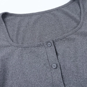 Gros plan d'un haut en maille gris foncé montrant la texture et deux boutons assortis