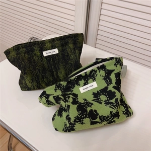 Detailed shot of vintage green and black jacquard fabric makeup bags with zippers