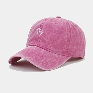 Detail of rose pink washed cotton baseball cap with white double heart embroidery
