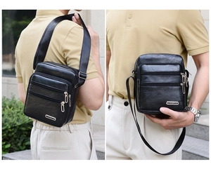 Detail of black PU leather crossbody bag with multiple zipper pockets and logo