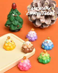 Macro detail of colorful mini resin Christmas trees with gold star toppers in a festive setting