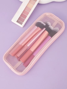 Détail de la trousse de maquillage en filet rose avec pinceaux, vue de dessus