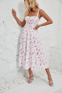 Detailed close-up of a floral summer dress with purple flowers and side slit design