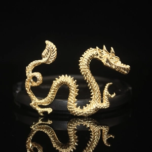 Detailaufnahme eines goldenen Drachenanhängers mit feinen Schuppen und Metallglanz