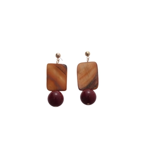 Elegant gold earrings with square brown shell and dark red round beads on white background