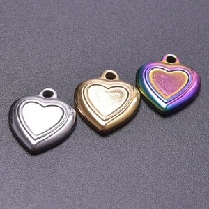 Three heart-shaped stainless steel pendants in silver, gold, and rainbow finishes