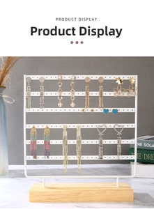 Detailed view of metal earring display stand with multi-layer holes and wooden base