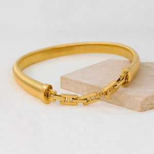Gold-plated snake bone chain bracelet with geometric clasp on stone base