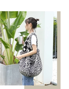 Close-up of leopard print canvas tote bag carried over the shoulder in natural light