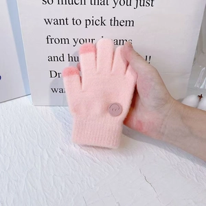 Detailed view of pink knitted gloves for girls with smiley patch and touchscreen fingertips