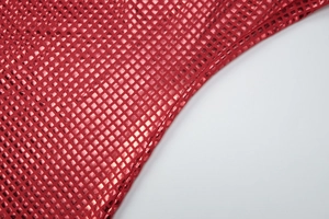 Gros plan sur le tissu métallique rouge avec motif de grille carrée et texture réfléchissante