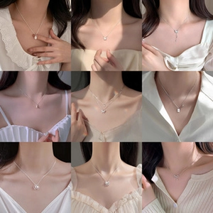 Collage of diverse silver necklaces featuring butterfly, pearl, and square pendant designs