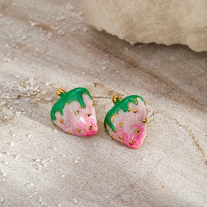 Detail of pink marble enamel strawberry earrings with gold accents and green leaves