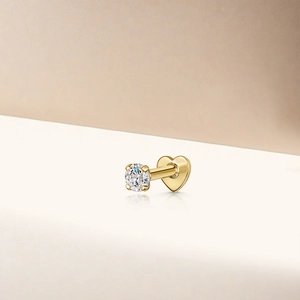 Macro shot of gold star earring with round zircon and heart-shaped flat back closure
