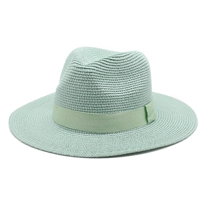 Macro view of mint green woven straw fedora hat featuring a matching silk ribbon band