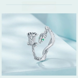 Detailed close-up of s925 silver snake ring with rose motif and green gemstone eyes
