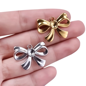 Macro shot of 304 stainless steel bow pendants in gold and silver finish for DIY jewelry