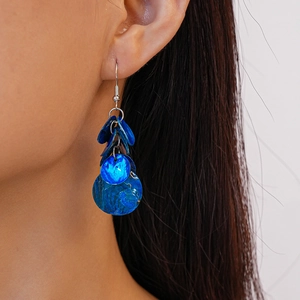 Gros plan de boucles d'oreilles pendantes en coquillage bleu sur un mannequin