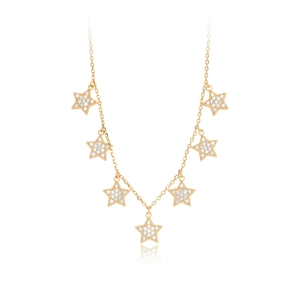 Detail of gold star necklace featuring white zircon pavé settings on a white background