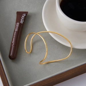 Elegant gold-plated stainless steel open bangle with a minimalist twisted wire design