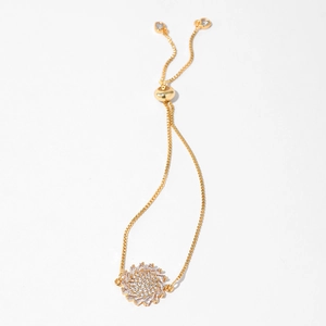 Detail of adjustable gold bracelet with heart charms and sparkling zircon centerpiece