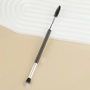Detailed shot of double-ended eyeshadow and spoolie brush with a sleek black handle