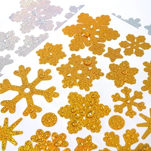 Macro detail of waterproof gold and silver glitter snowflake stickers with shiny texture