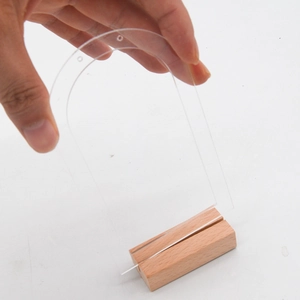 Détail montrant l'assemblage manuel du présentoir à bijoux en acrylique sur son socle