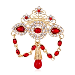 Detail of vintage golden sparrow brooch with red crystal teardrop and sparkling rhinestones