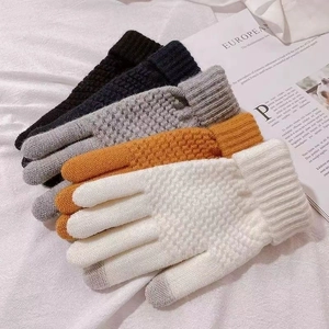 Detail of colorful knitted touchscreen gloves with honeycomb pattern and ribbed cuffs