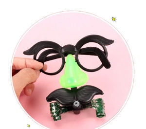 Close-up of novelty LED party glasses featuring a black frame with green nose and mustache