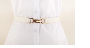 Detailed view of white elastic waist belt with gold metal buckle on a white shirt